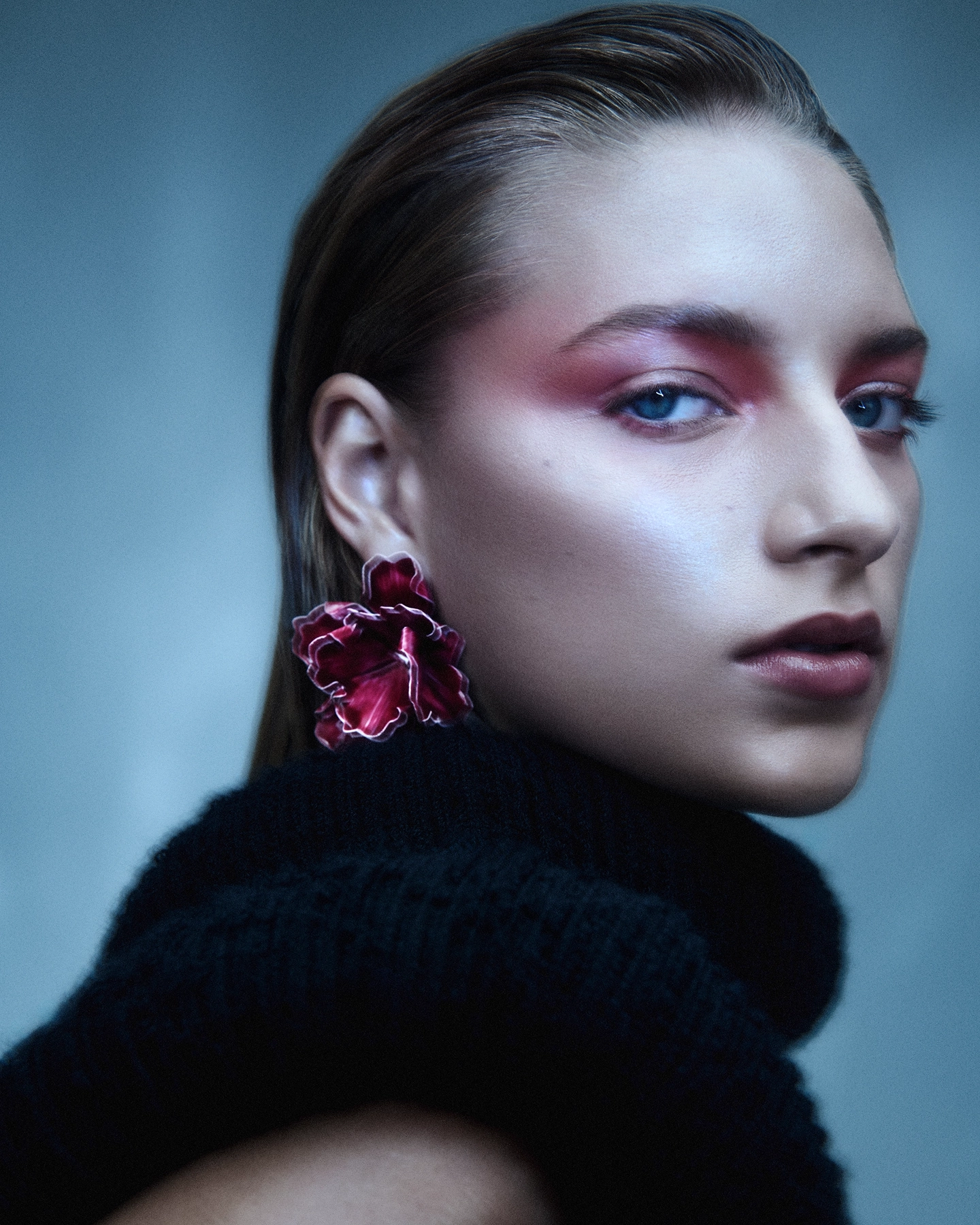Close-up with pink eyeshadow, floral earring and dark knit turtleneck in blue-toned light for 5 Eleven Magazine Corals series, makeup by Karissa McLaren