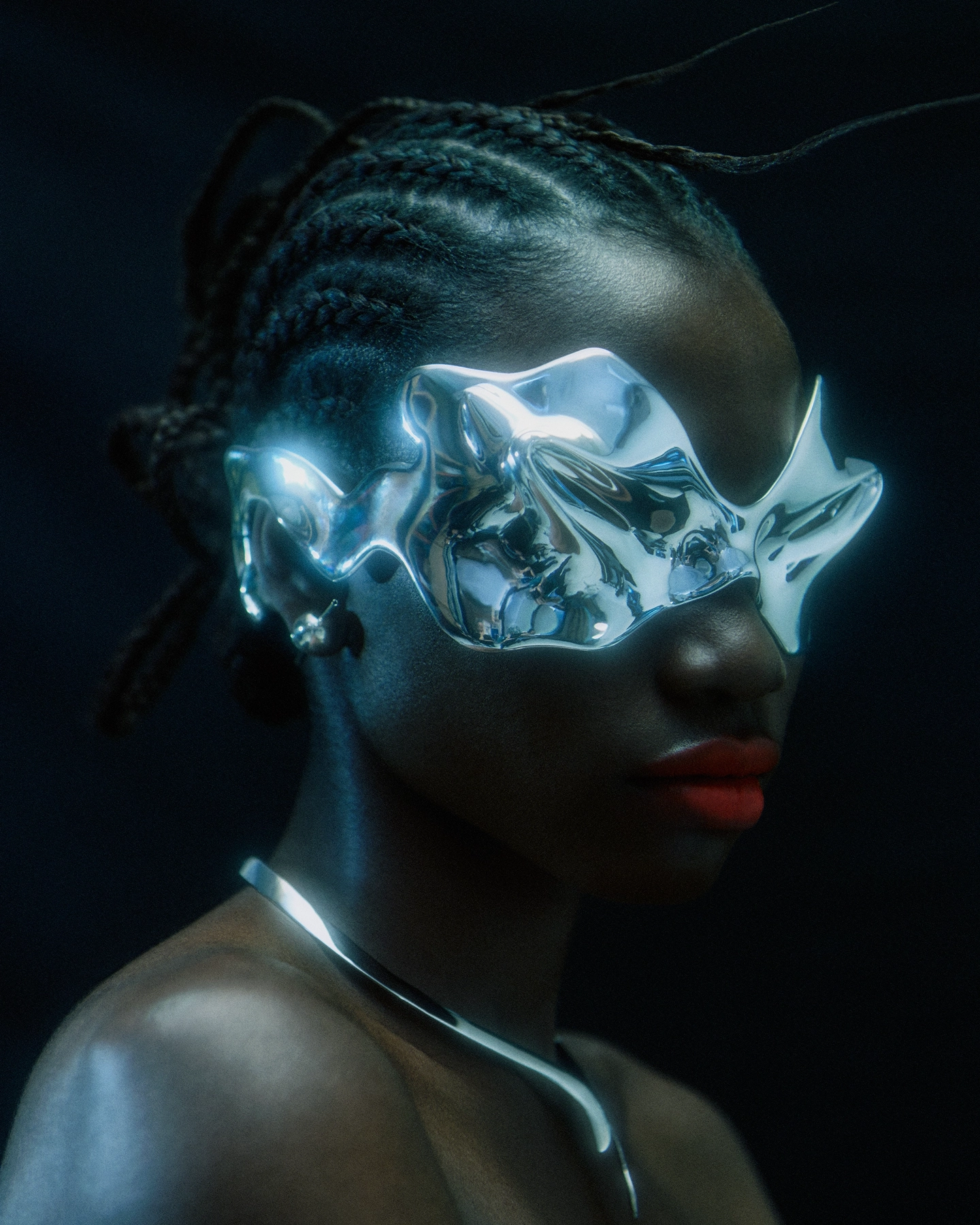 Gifty with chrome sculptural face mask, braided hair and red lip in blue-toned light for Schon Magazine, styled by Carlos Mangubat, hair by Bjorn Krischker