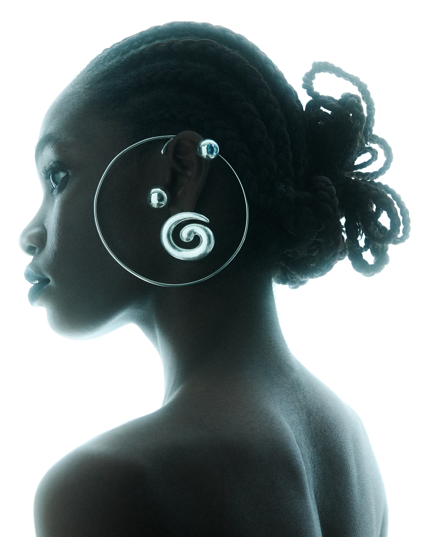 Gifty silhouette profile with spiral wire ear accessory, backlit against white background for Schon Magazine, styled by Carlos Mangubat, hair by Bjorn Krischker