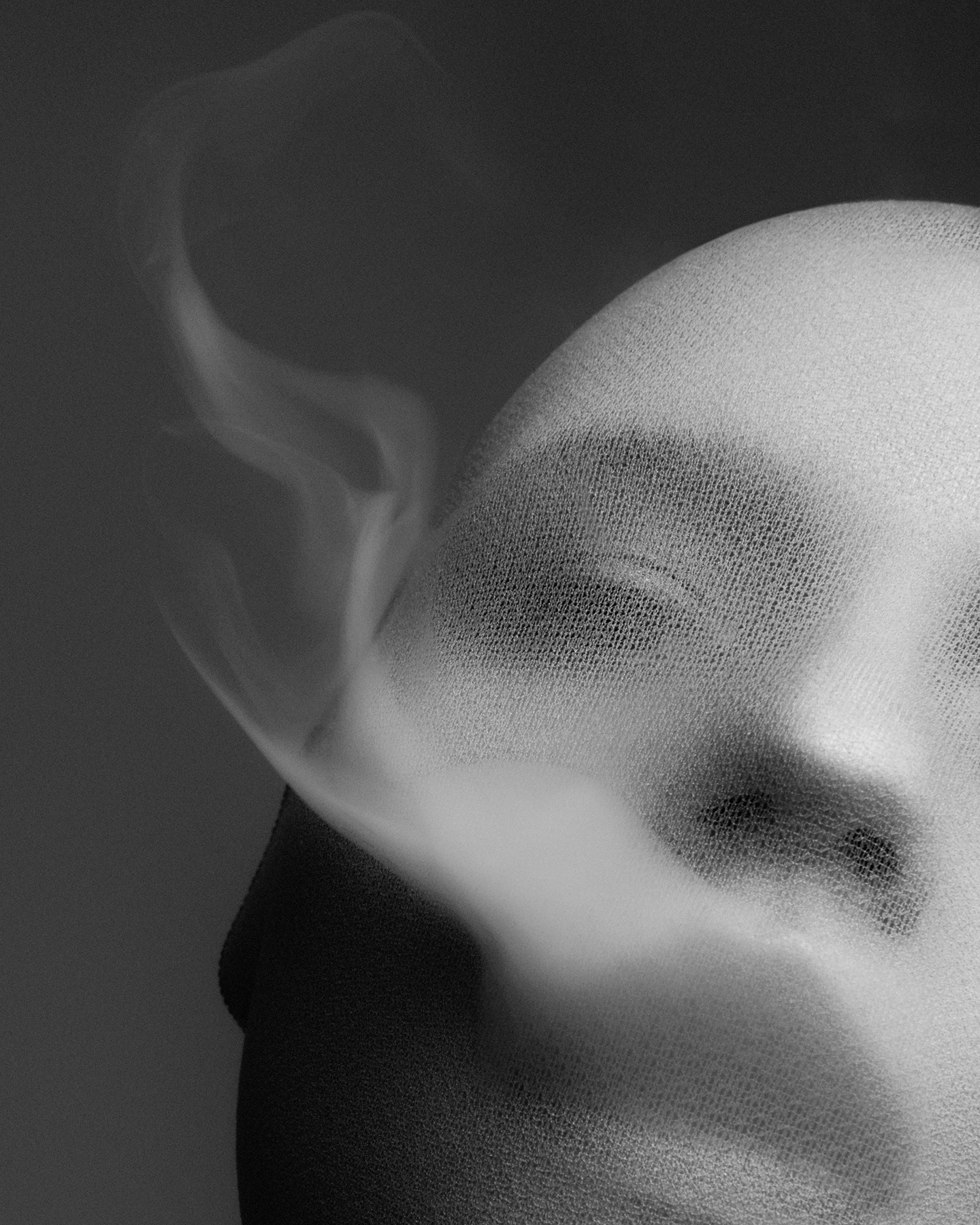 Black and white portrait with gauze-wrapped face and wisps of smoke rising, ethereal beauty concept