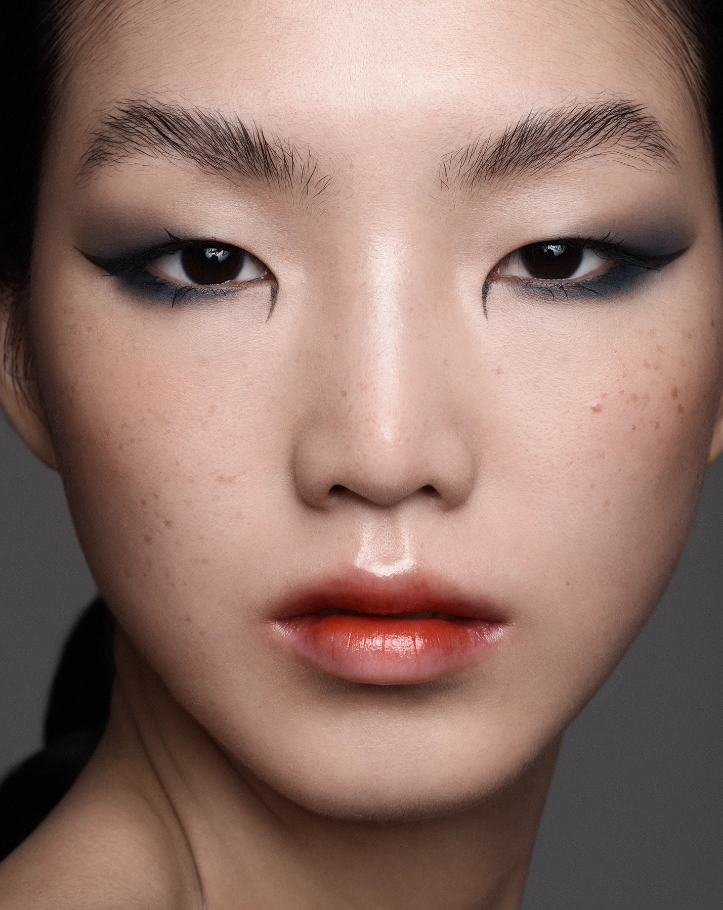 Hannah extreme close-up beauty portrait with dramatic black winged eyeliner and coral lip
