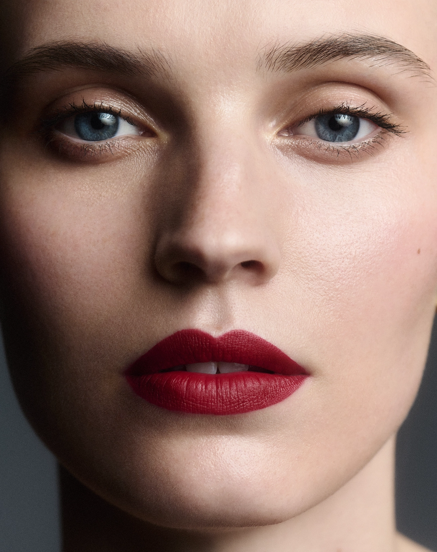 Agnes close-up beauty portrait with blue eyes, deep red matte lip and soft studio lighting