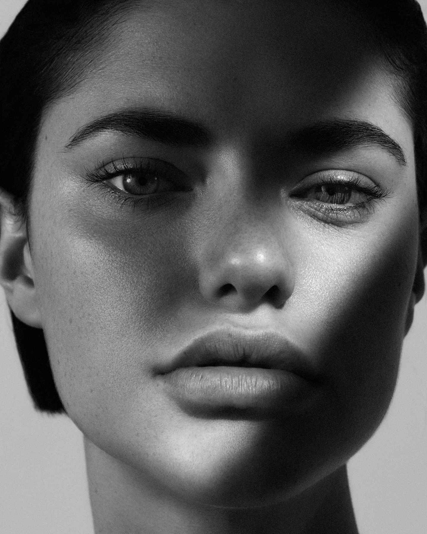 Black and white close-up beauty portrait with natural skin texture and direct gaze