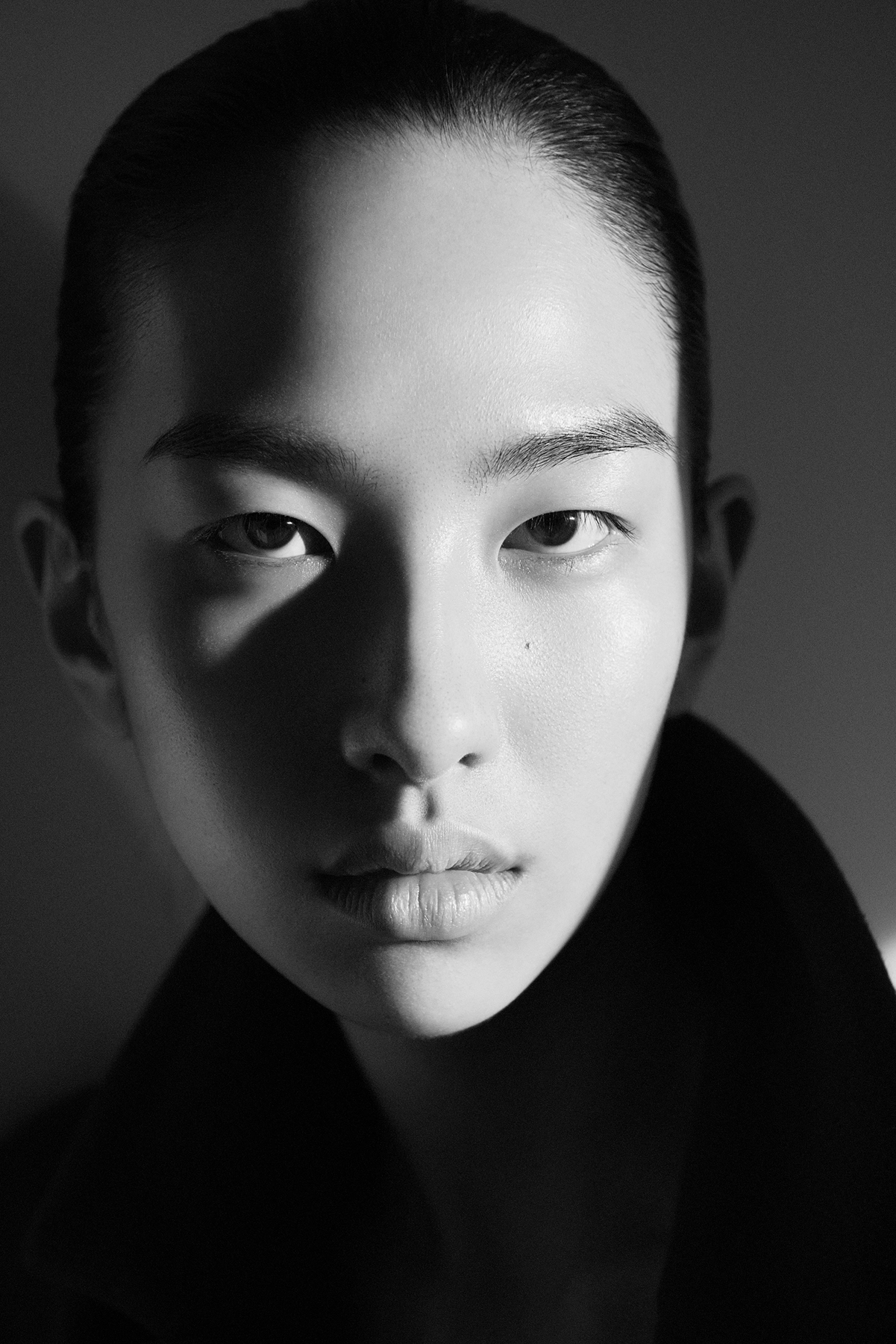 Cecilia black and white close-up portrait with dramatic shadow play and high-neck top