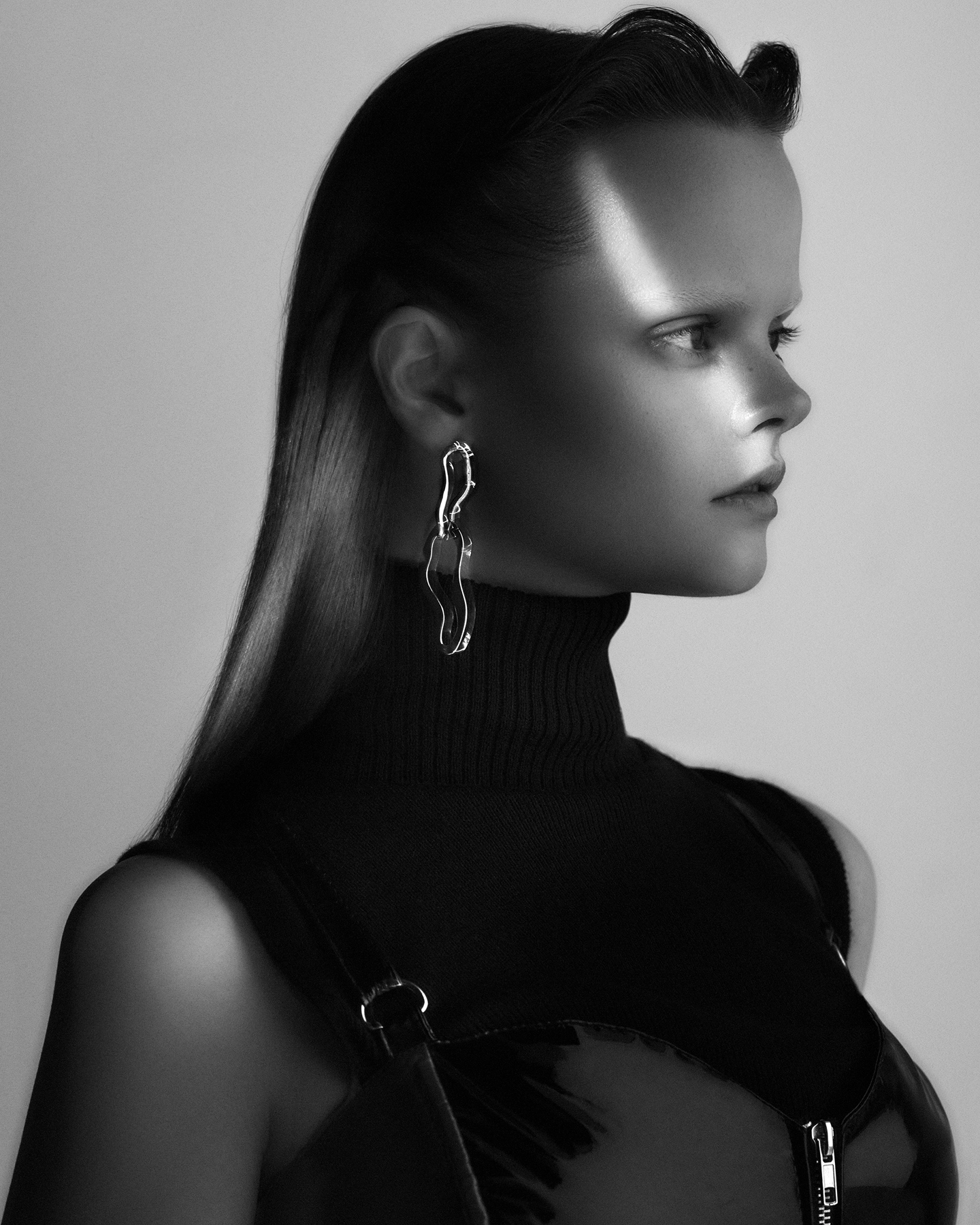 Melissa Juratowitch black and white profile with sleek ponytail, sculptural chain earring and turtleneck for LOfficiel Vietnam, styled by Carlos Mangubat, hair by Yoko Setoyama