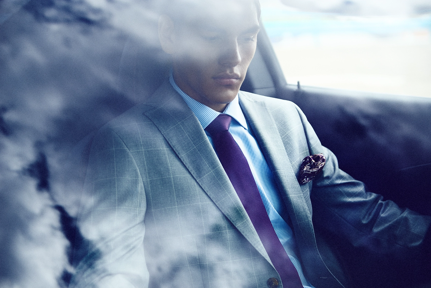 Double exposure of man in plaid suit with purple tie overlaid with dramatic clouds, American Muscle editorial