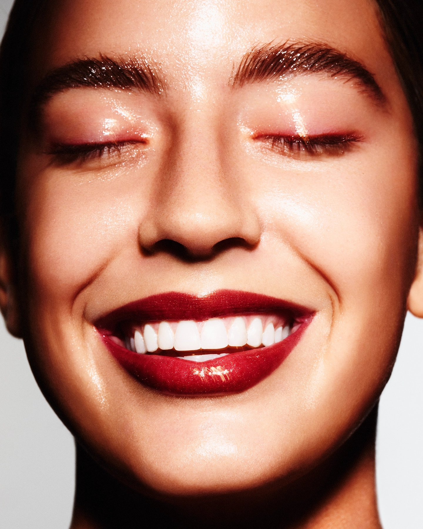 Jayde joyful close-up beauty portrait with closed eyes, glowing skin and classic red lip